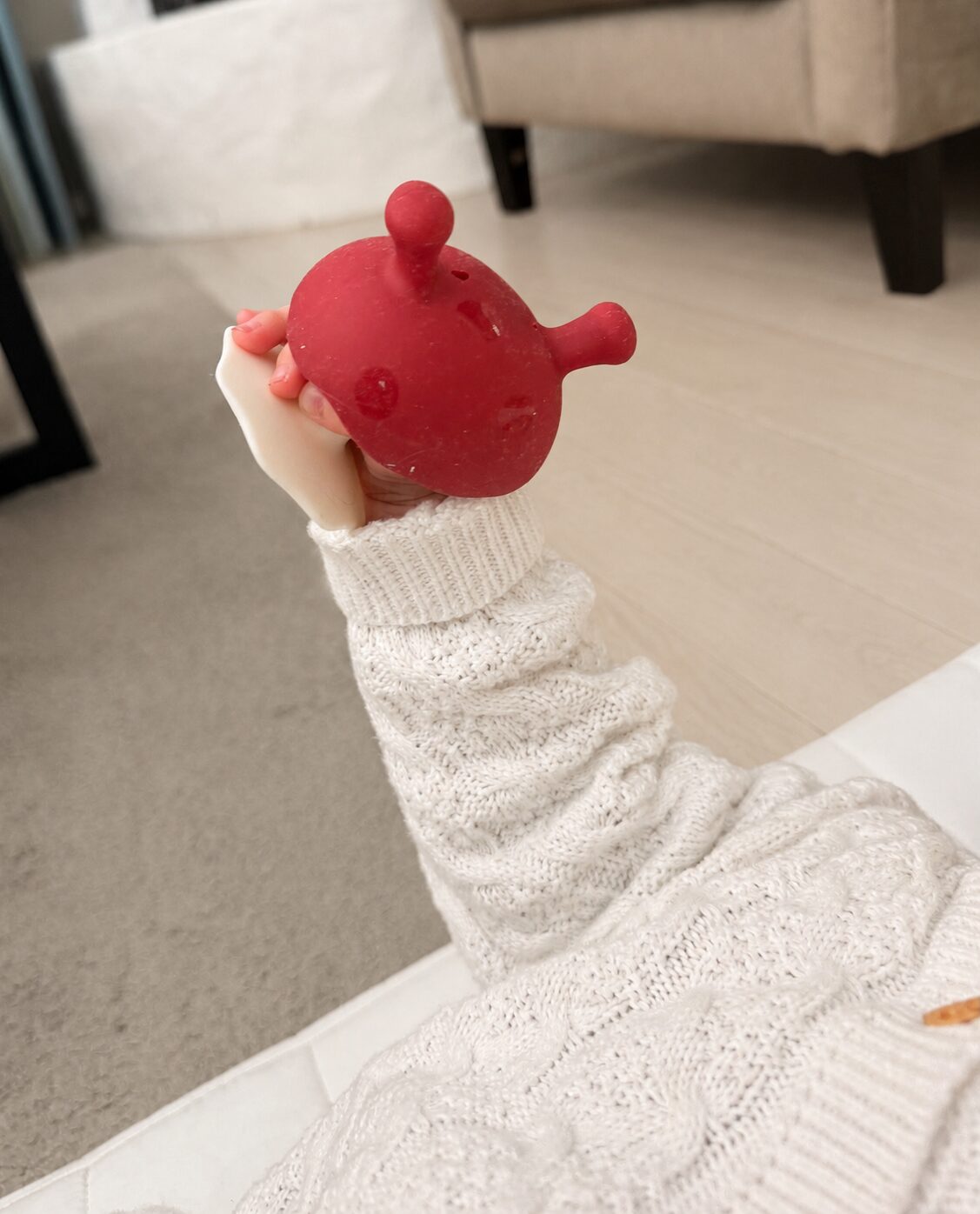 Babyhånd som holder den røde Mombella-soppen selv